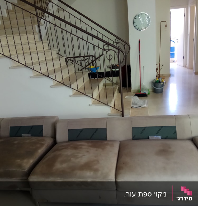 ספה עם כתמים, מטאטא ודלי לניקוי